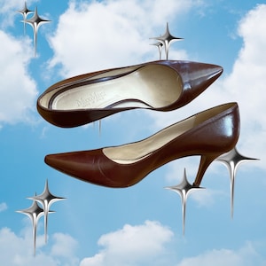 May include: A pair of dark brown leather court shoes with a pointed toe and a slim heel. The interior of the shoe features the brand name MaxMara and the text Made in Italy printed in gold on the light beige insole. The shoes are set against a blue sky.