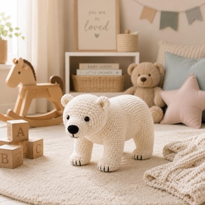 May include: A cream-colored, crocheted polar bear toy with a black nose and black eyes. The bear is standing on all fours, featuring a textured yarn surface and small, rounded ears. The toy is crafted with visible stitches and has black thread details on its paws.