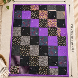 Pu&ograve; includere: Una trapunta patchwork rettangolare con una griglia di quadrati in tessuto viola tinta unita alternati a vari motivi in nero, viola e giallo. La trapunta misura 150 x 200 cm e presenta nodi bianchi visibili annodati a mano su ogni quadrato.