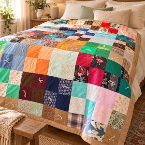 May include: A patchwork quilt featuring a grid of multi-colored fabric squares in various patterns, including floral, plaid, and solid colors. The quilt is tied with small white yarn knots at regular intervals and finished with a solid tan border.