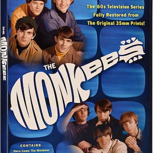 Puede incluir: Una caja de DVD de la serie de televisión The Monkees con un fondo azul y formas rectangulares redondeadas. La portada muestra fotos de los cuatro miembros de la banda y el texto: The 60s Television Series Fully Restored from The Original 35mm Prints! Contains Here Come The Monkees, The Picture Frame, Alias Micky Dolenz, Monkees Marooned.