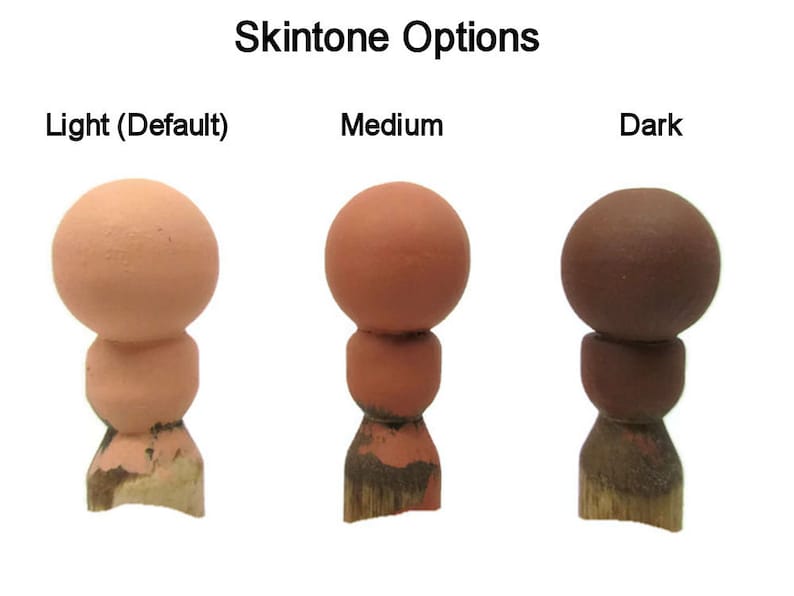 May include: Three wooden doll heads painted in different skin tones: light, medium, and dark. The heads are on wooden bases.