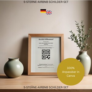 May include: A wooden frame containing a sign with the text Herzlich Willkommen! Welcome! and a QR code for Wi-Fi access. The sign includes instructions in German and English for manual login, network name, and password. A round vase and a tall vase are present.