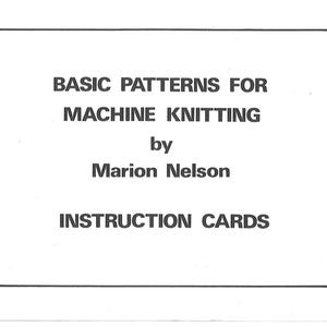 May include: A rectangular white card with rounded corners featuring black text that reads: BASIC PATTERNS FOR MACHINE KNITTING by Marion Nelson INSTRUCTION CARDS. The text is centred and printed in a simple, bold, sans-serif typeface.