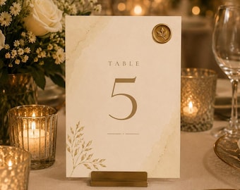Números de mesa para bodas en color crema y dorado: Tarjetas de recepción editables en Canva