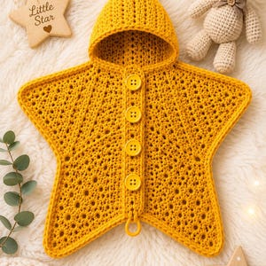 May include: A mustard yellow star-shaped hooded garment made of crocheted yarn. The piece features a pointed hood and a vertical front placket secured with four matching yellow buttons. The texture is consistent with a knit or crochet pattern.