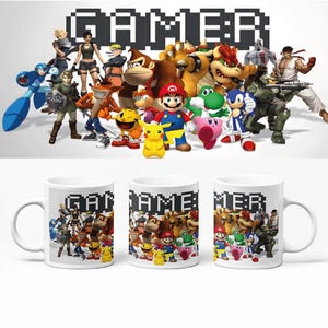 Könnte beinhalten: Drei weiße Keramikbecher mit einem farbenfrohen Grafikdruck verschiedener Videospielcharaktere wie Mario, Pikachu, Sonic und Link. Das Wort GAMER ist in einer schwarzen, verpixelten Schrift über den Charakteren auf jedem Becher abgebildet.