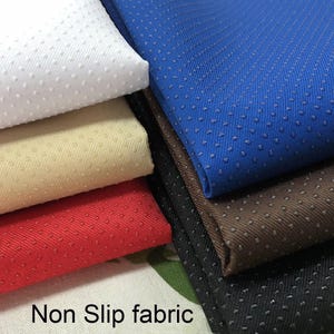 May include: A collection of non-slip fabric swatches in white, beige, red, blue, brown, and black. Each piece of fabric features a diagonal weave pattern and a uniform grid of small, raised rubberized dots on the surface to provide grip.