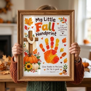 Könnte beinhalten: Ein gerahmter Druck mit dem Titel My Little Fall Handprint und einem Handabdruck in Orange, Gelb und Rot. Das Design zeigt ein Holzkreuz mit weißem Tuch, Kürbisse, Sonnenblumen, Herbstblätter sowie die Bibelverse Psalm 139,14 und 107,1.