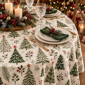 Peut inclure: Une nappe ronde ornée d'un motif répétitif de sapins de Noël verts, de baies rouges et de flocons de neige blancs sur fond crème. La table est dressée avec des assiettes blanches, des couverts dorés, des verres en cristal et un centre de table.