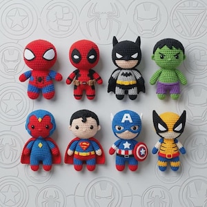 May include: A collection of eight crocheted dolls representing various comic book characters, including Spider-Man, Deadpool, Batman, Hulk, Vision, Superman, Captain America, and Wolverine, each featuring distinct colors and iconic costume details.