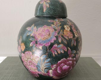 Puede incluir: Un tarro de jengibre de cerámica de color verde oscuro con tapa a juego, que presenta un patrón floral pintado a mano de grandes peonías rosas y moradas con hojas azuladas y contornos dorados en toda la superficie del recipiente.