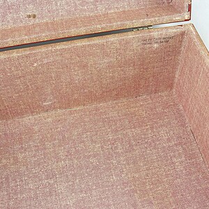 May include: Open vintage box with a red fabric interior. The box is lined with a textured, reddish-pink material. The lid is open, revealing the inside of the box. The text "Stanley Case Works" is visible.