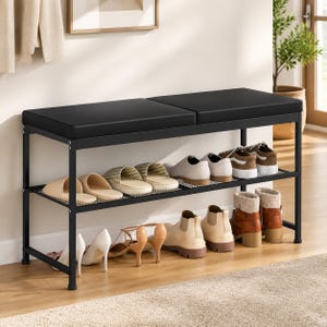 May include: A black metal shoe bench featuring a rectangular padded seat and two open storage shelves. The frame is constructed from thin black metal tubing, and the unit is filled with various styles of footwear, including boots, heels, and flats.