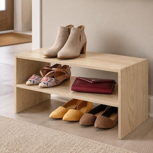 May include: A light wood shoe rack with two open shelves. The top shelf holds a pair of beige ankle boots. The bottom shelf holds a pair of floral print flats, a dark red clutch, a pair of yellow pointed flats, and a pair of brown leopard print flats.