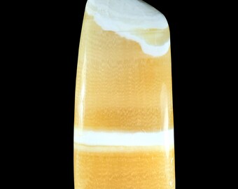 May include: A polished, vertical, semi-translucent stone specimen featuring horizontal bands of golden yellow and opaque white. The mineral has a smooth, glossy surface with a rounded top edge and a flat base, displaying natural color variations.