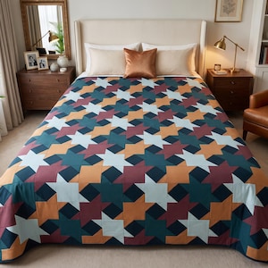 Op de afbeelding: Een quilt met een herhalend geometrisch sterpatroon in een palet van diep petrol, gebrand oranje, donker bordeauxrood en lichtblauw. De stof is doorgestikt met een rasterontwerp en bedekt het bedoppervlak met een gladde afwerking.