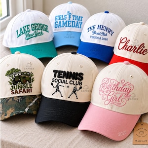 May include: Seven baseball caps with various embroidered designs. Caps feature text including Lake George, Girls That Gameday, The Henry Social Club, Charlie, Jungle Safari, Tennis Social Club, and Birthday Girl, with colorful brims and patterns.