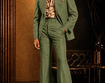 May include: A sage green suit featuring a blazer with wide lapels and matching high-waisted flared trousers. The ensemble is paired with a tan and brown patterned button-down shirt with a wide collar, a matching pocket square, and tinted sunglasses.