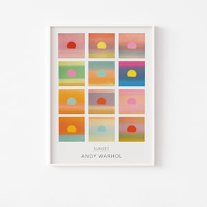 Op de afbeelding: Een rechthoekige kunstdruk met een raster van twaalf vierkante panelen, elk met een gestileerde zonsondergang met een effen gekleurde cirkel tegen een gradiëntachtergrond. De tekst SUNSET en ANDY WARHOL staat in het zwart onderaan de print.