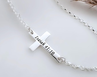 Könnte beinhalten: Eine silberfarbene Halskette mit einem horizontalen Kreuzanhänger. Das Kreuz ist mit dem schwarzen Text Isaiah 41:10 graviert. Der Anhänger ist an einer zarten silberfarbenen Kette mit runden Gliedern befestigt, was ein schlichtes Design ergibt.