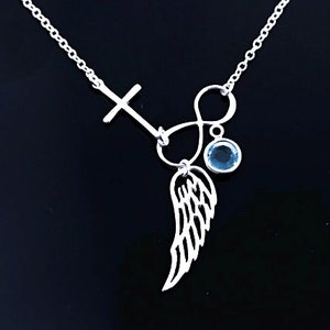 May include: Silver necklace featuring a cross, infinity symbol, and a single blue gemstone. The pendant incorporates a delicate wing design.