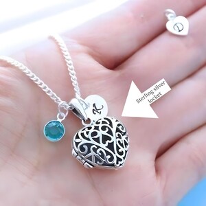Puede incluir: Un collar de plata con un dije en forma de coraz&oacute;n con un delicado dise&ntilde;o de filigrana. El dije tiene un peque&ntilde;o dije de piedra turquesa y un dije redondo con la letra "K" grabada. El collar est&aacute; en una cadena de plata.