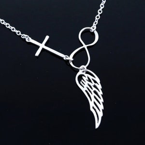 May include: Silver necklace featuring a cross, infinity symbol, and a single wing pendant.