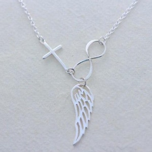 May include: Silver necklace featuring a cross, infinity symbol, and a single wing pendant.