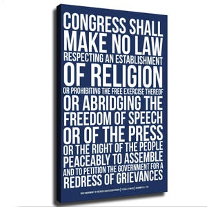 Könnte beinhalten: Ein rechteckiges Wandbild auf Leinwand mit dunkelblauem Hintergrund und fettgedrucktem weißem Text, der den ersten Zusatzartikel zur Verfassung der Vereinigten Staaten zeigt. Der Text lautet: Congress shall make no law respecting an establishment of religion.