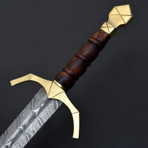 May include: A dagger featuring a patterned Damascus steel blade, a polished brass crossguard with downward-curving quillons, and a dark brown wooden handle with a ribbed texture, finished with a geometric brass pommel at the end.