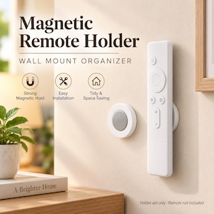 May include: A white magnetic remote holder wall mount organiser with text reading Magnetic Remote Holder WALL MOUNT ORGANISER. The set includes a circular magnetic base and a matching magnetic disc attached to a white remote control.