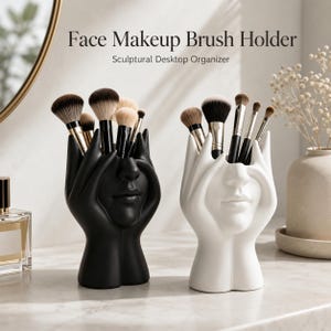 Puede incluir: Un soporte para brochas de maquillaje negro y otro blanco, cada uno diseñado como un organizador de escritorio escultórico con forma de manos que sostienen un rostro. El texto Face Makeup Brush Holder Sculptural Desktop Organizer es visible.