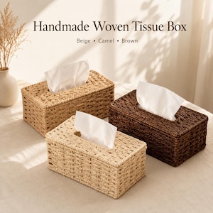 May include: Three rectangular handmade woven tissue boxes in beige, camel, and dark brown, each containing white tissues. The text "Handmade Woven Tissue Box" and "Beige • Camel • Brown" is printed above the boxes in a dark brown serif font.