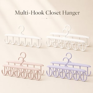 Puede incluir: Un juego de perchas multi-gancho para armario en blanco, rosa claro y morado claro. Cada percha cuenta con un gancho giratorio central unido a una barra horizontal con seis ganchos orientados hacia abajo para organizar accesorios o prendas.
