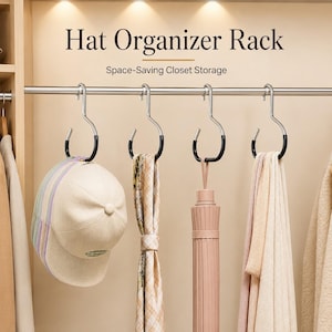 Op de afbeelding: Een zilverkleurig metalen hoedenrek met zwart rubberen haken hangend aan een kledingroede. De tekst luidt Hat Organizer Rack en Space-Saving Closet Storage. Aan de haken hangen een beige baseballpet, een sjaal en een paraplu.