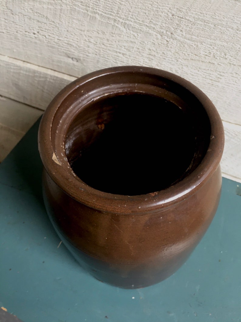 Puede incluir: Un gran tarro de cer&aacute;mica marr&oacute;n esmaltado con una abertura ancha. El tarro est&aacute; vac&iacute;o y tiene una superficie lisa ligeramente texturizada.