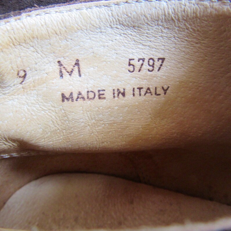 May include: Close-up of the inside of a brown leather shoe. The shoe is labeled with a size 9, a size M, and the number 5797. The shoe is also labeled "Made in Italy."