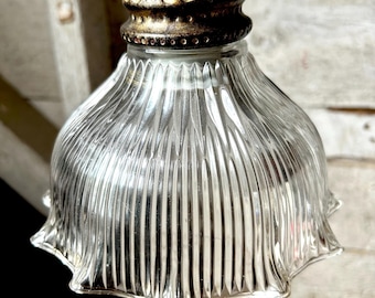 Op de afbeelding: Transparante glazen hanglamp met een geribbelde kap en een decoratieve messingkleurige bovenkant. De kap heeft een geschulpte rand. De lamp hangt aan een messingkleurige stang.