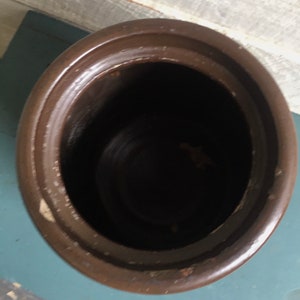 Puede incluir: Una maceta de cer&aacute;mica marr&oacute;n con una abertura ancha. La maceta est&aacute; vac&iacute;a y tiene un acabado liso y esmaltado.