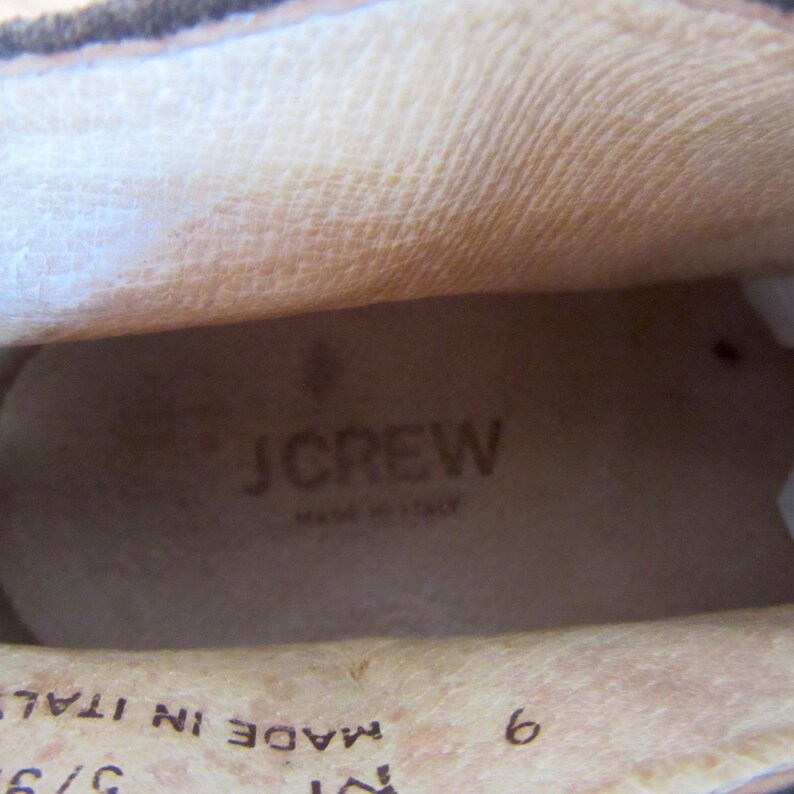 May include: Close-up of the inside of a brown leather shoe. The insole is beige and has the text "J.CREW MADE IN ITALY" printed on it. The size 6 is also visible.