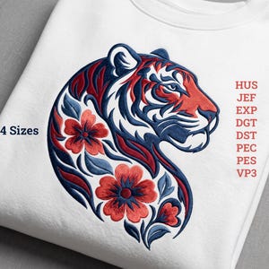 Könnte beinhalten: Ein weißes Sweatshirt mit einer gestickten Tigerkopf-Silhouette in Marineblau und Rot, verziert mit roten Blumenmotiven. Links steht der Text 4 Sizes, rechts sind die Dateiformate HUS, JEF, EXP, DGT, DST, PEC, PES und VP3 aufgeführt.