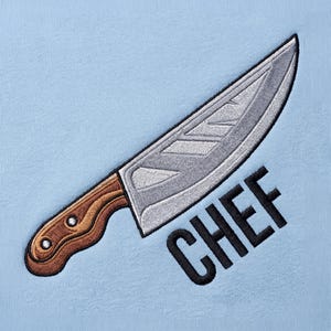 Puede incluir: Un fondo de tela azul claro con un diseño bordado de un cuchillo de chef plateado con mango de madera marrón. La palabra CHEF está bordada en letras mayúsculas negras y negritas, posicionada en diagonal debajo de la hoja.