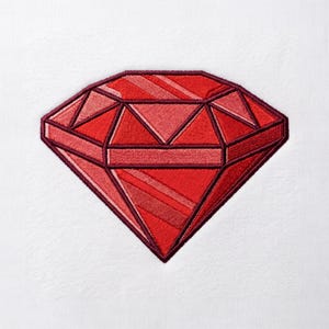 May include: An embroidered patch featuring a faceted gemstone design in various shades of red. The diamond-shaped graphic is outlined in a dark maroon thread, with internal geometric sections filled with bright red and deep crimson stitching.