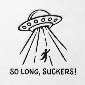Può includere: Una superficie in tessuto bianco con un ricamo a macchina nero che raffigura un UFO che sorvola una persona rapita da un raggio di luce. Il testo "SO LONG, SUCKERS!" è ricamato in lettere maiuscole nere sotto il disegno centrale.