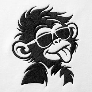 Könnte beinhalten: Ein schwarz-weiß gestickter Aufnäher, der einen stilisierten Affen mit Sonnenbrille und herausgestreckter Zunge zeigt. Das Design besticht durch detaillierte Stickereien des Fells, der Ohren und der Gesichtszüge auf einem schlichten weißen Stoff.