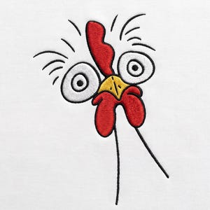 May include: An embroidered graphic on a white fabric surface featuring a stylised chicken head with large white eyes, black pupils, a bright red comb, a yellow beak, and red wattles. The design includes thin black lines representing feathers.