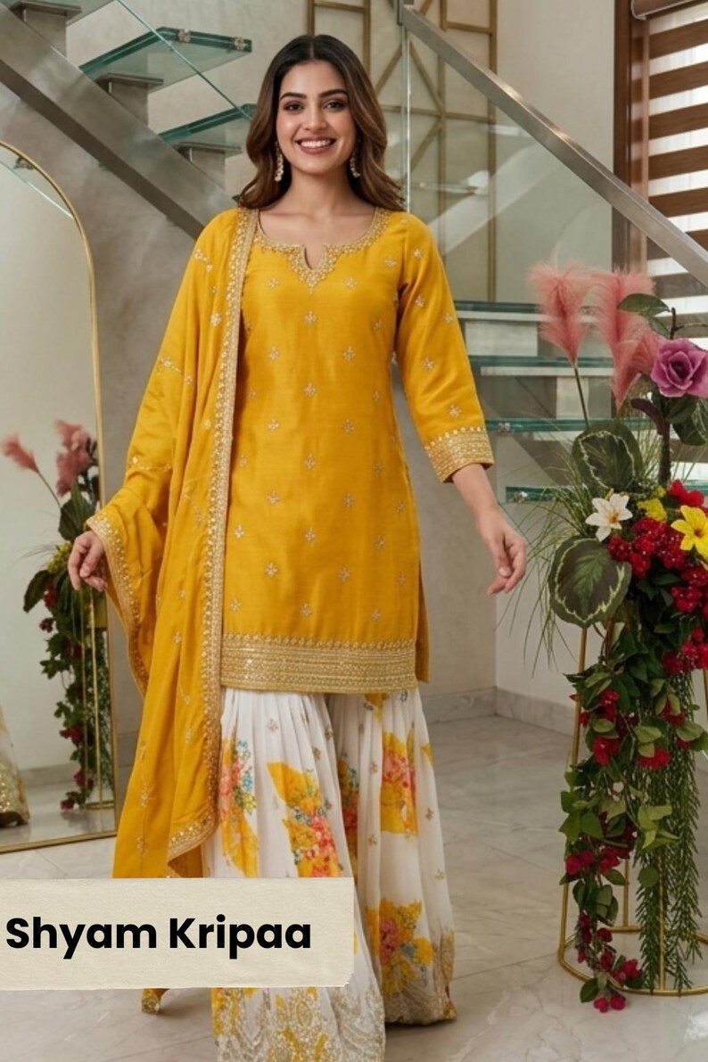 May include: A yellow kurta with gold embroidery around the neckline and hem, paired with a matching yellow dupatta featuring gold trim and white palazzo pants with a yellow and orange floral print. The text Shyam Kripaa is visible.