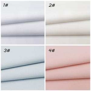 May include: A grid of four fabric swatches featuring a diagonal twill weave pattern. The top left swatch is bright white labeled 1#, the top right is off-white labeled 2#, the bottom left is light blue labeled 3#, and the bottom right is light pink labeled 4#.
