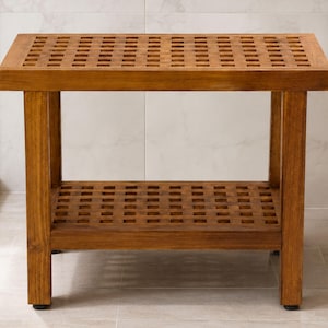 May include: A rectangular wooden bench featuring a slatted top and a lower shelf, both constructed with a grid pattern of square openings. The furniture piece is finished in a warm brown tone and stands on four sturdy legs with black feet.